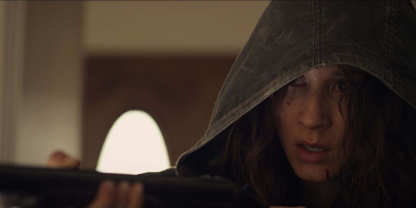 Troian Bellisario as Lucie holding a shotgun in Martyrs (2015)