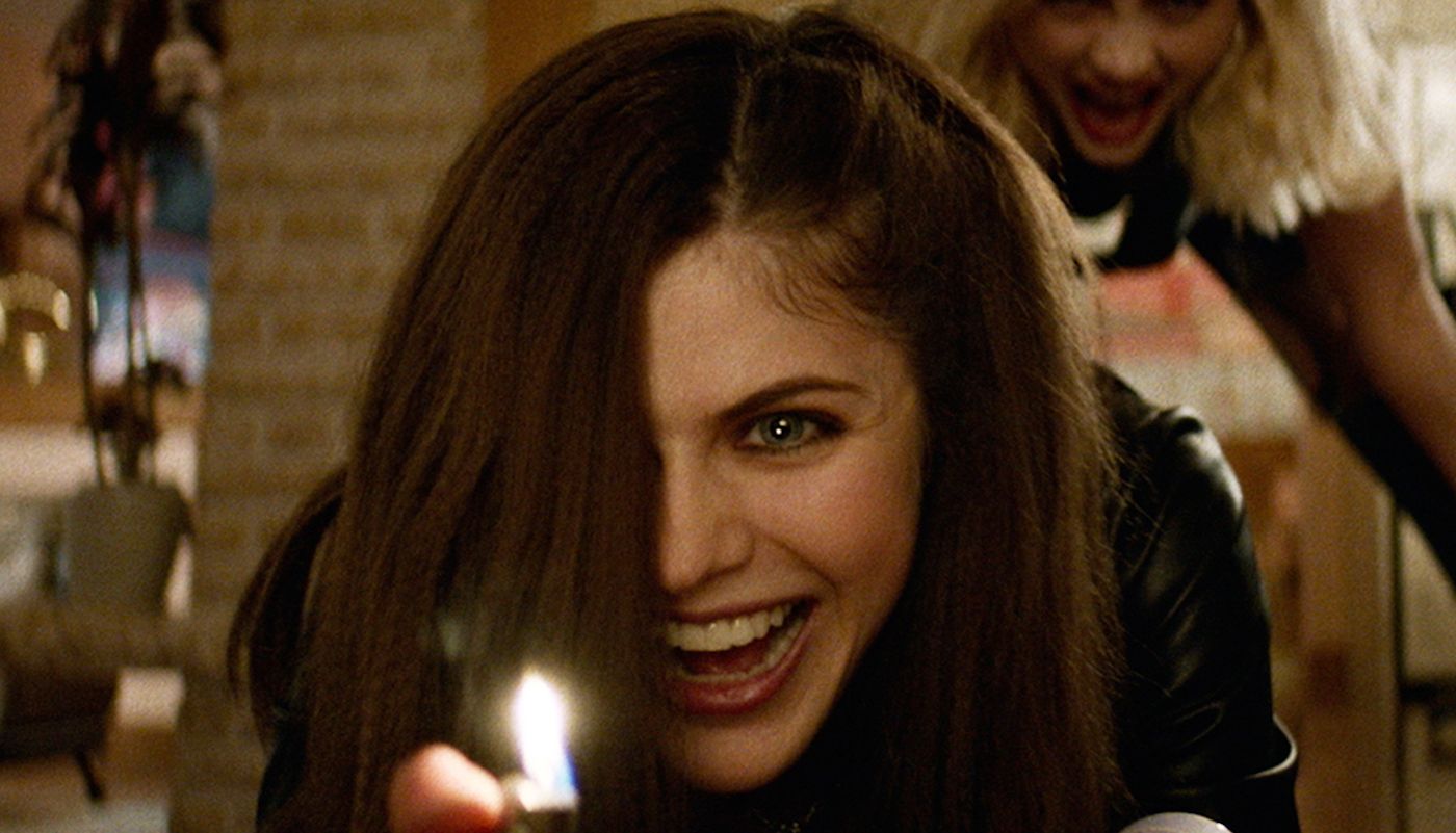 Alexandra Daddario as Alexis holding a lighter while smiling maniacally in We Summon the Darkness