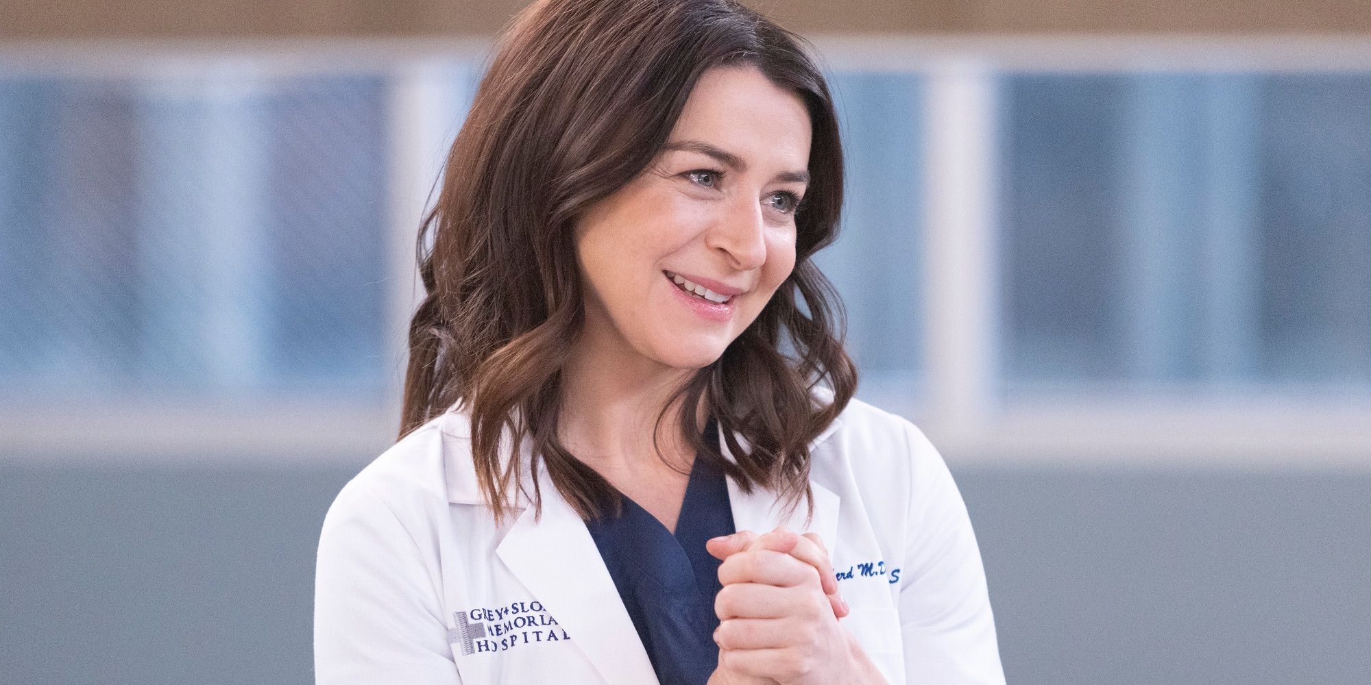 Caterina Scorsone as Amelia Shepherd, smiling and clasping her hand in Grey's Anatomy