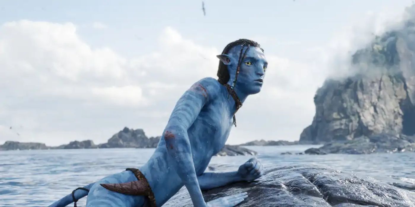 Sam Worthington as Jake Sully on rock in  the ocean looking to the distance in Avatar: The Way of Water