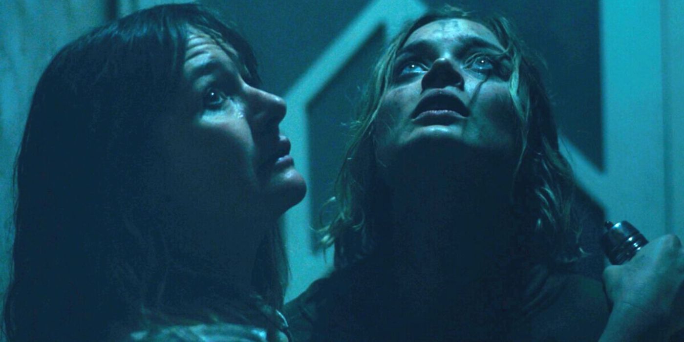 Bella Heathcote and Emily Mortimer looking up at something in the dark in Relic (2020)