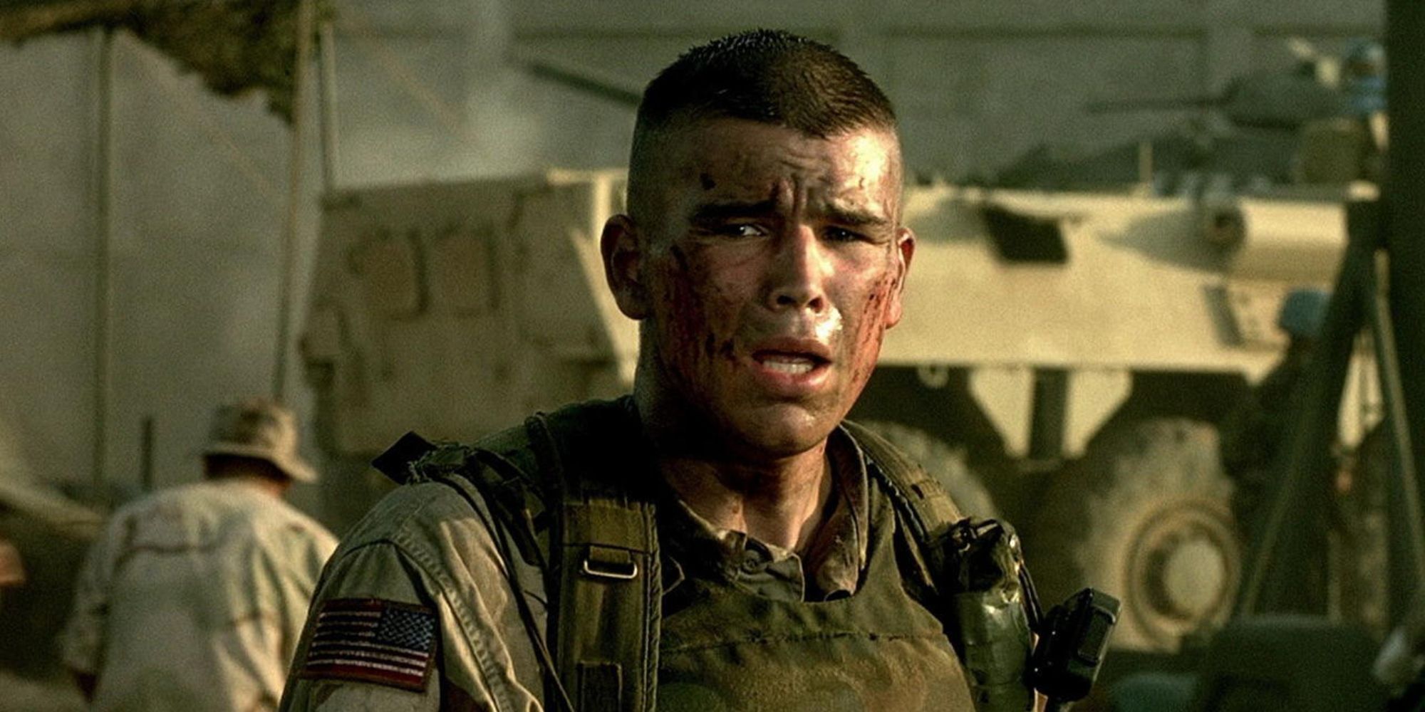 An army sergeant with a bloodied face looks distraught as he stands in a military compound.