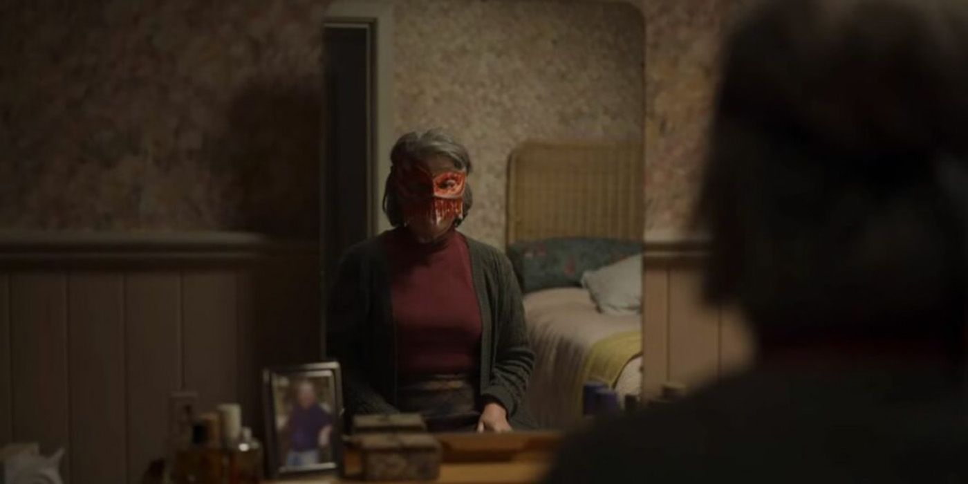 Janet sitting in front of the mirror wearing her red face mask in a scene from Black Mirror, Loch Henry.