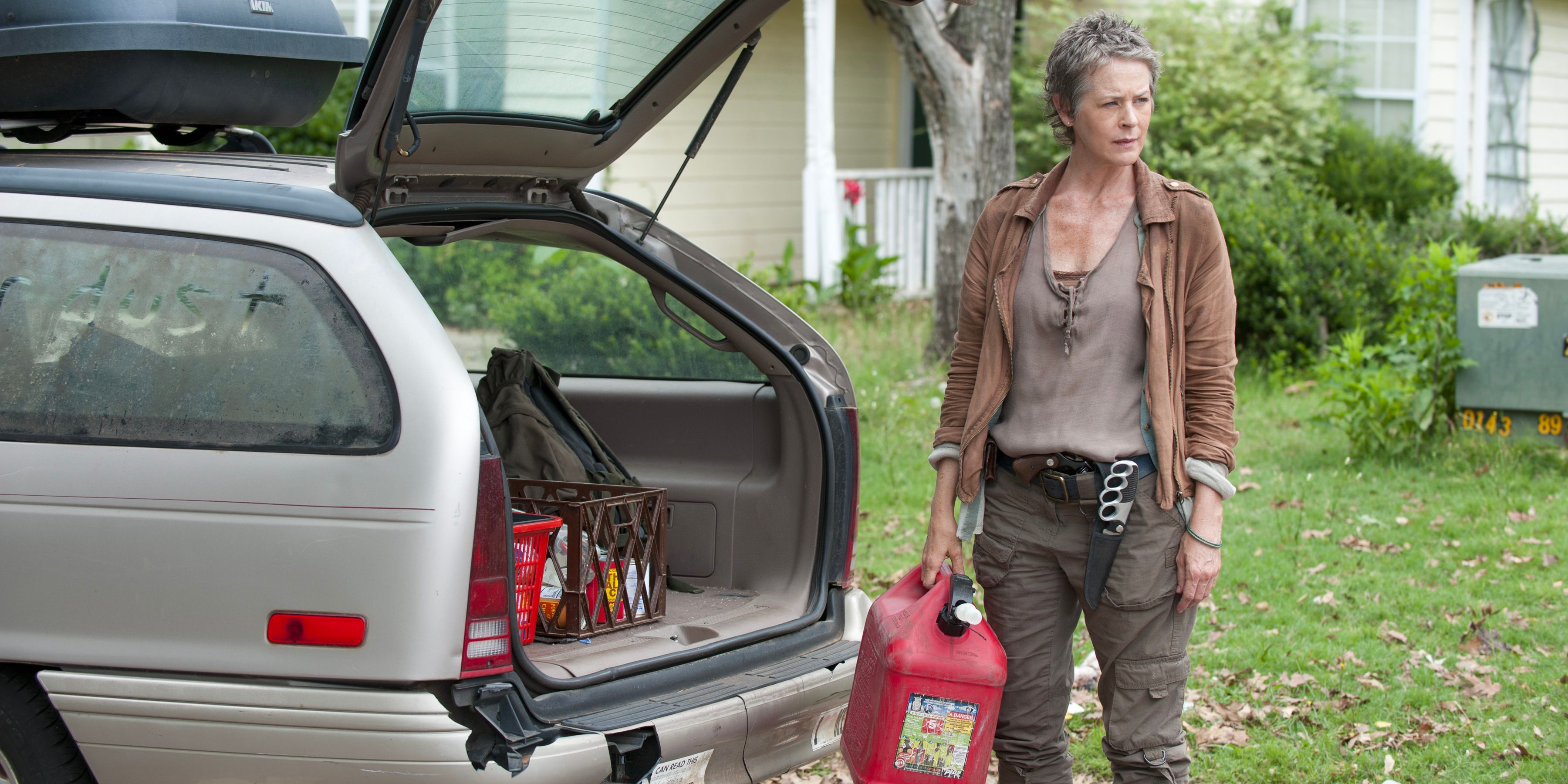 Carol Peletier packs the boot of a car while sporting her trench knife on her belt. 