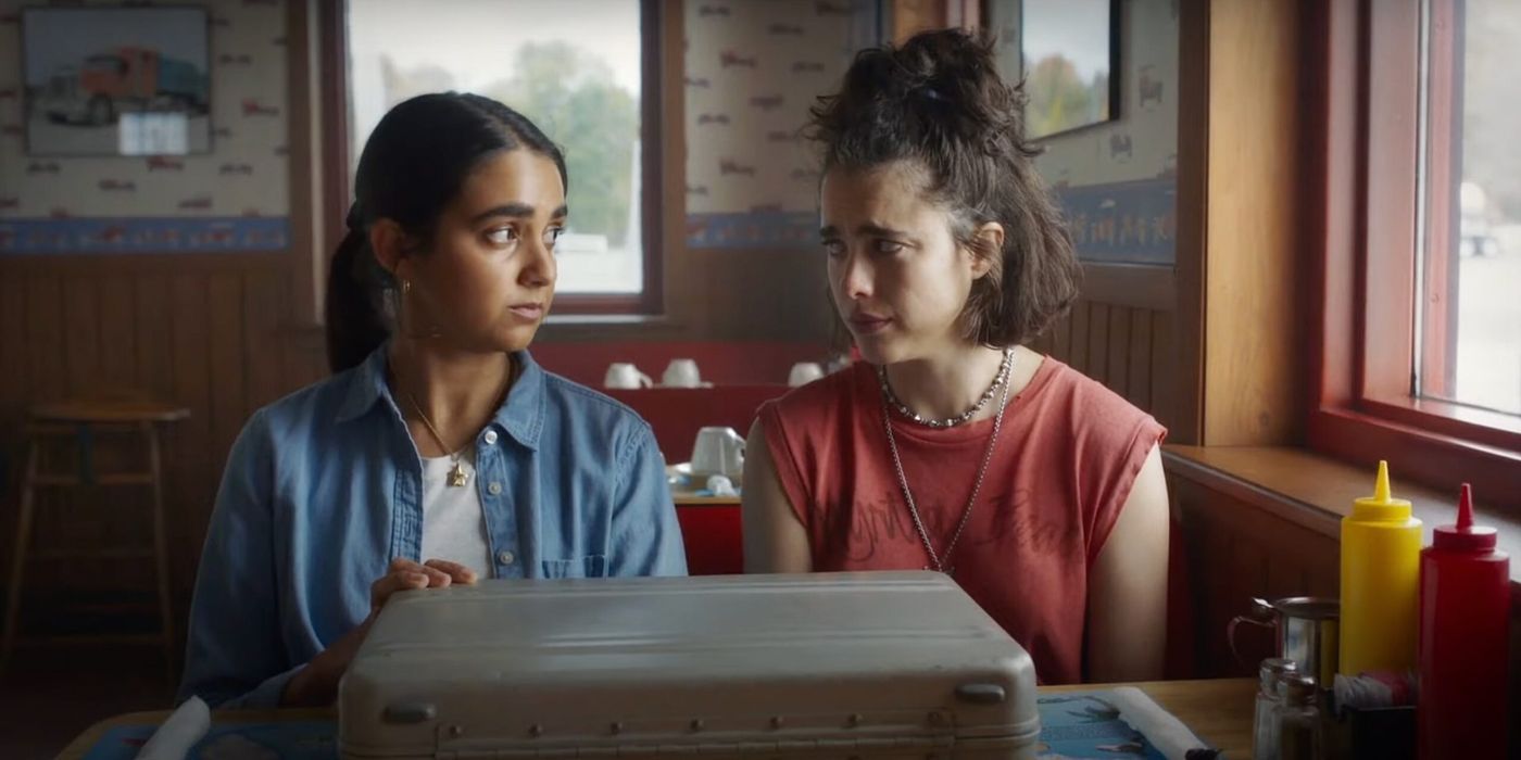 Geraldine Viswanathan and Margaret Qualley sit with briefcases in a diner