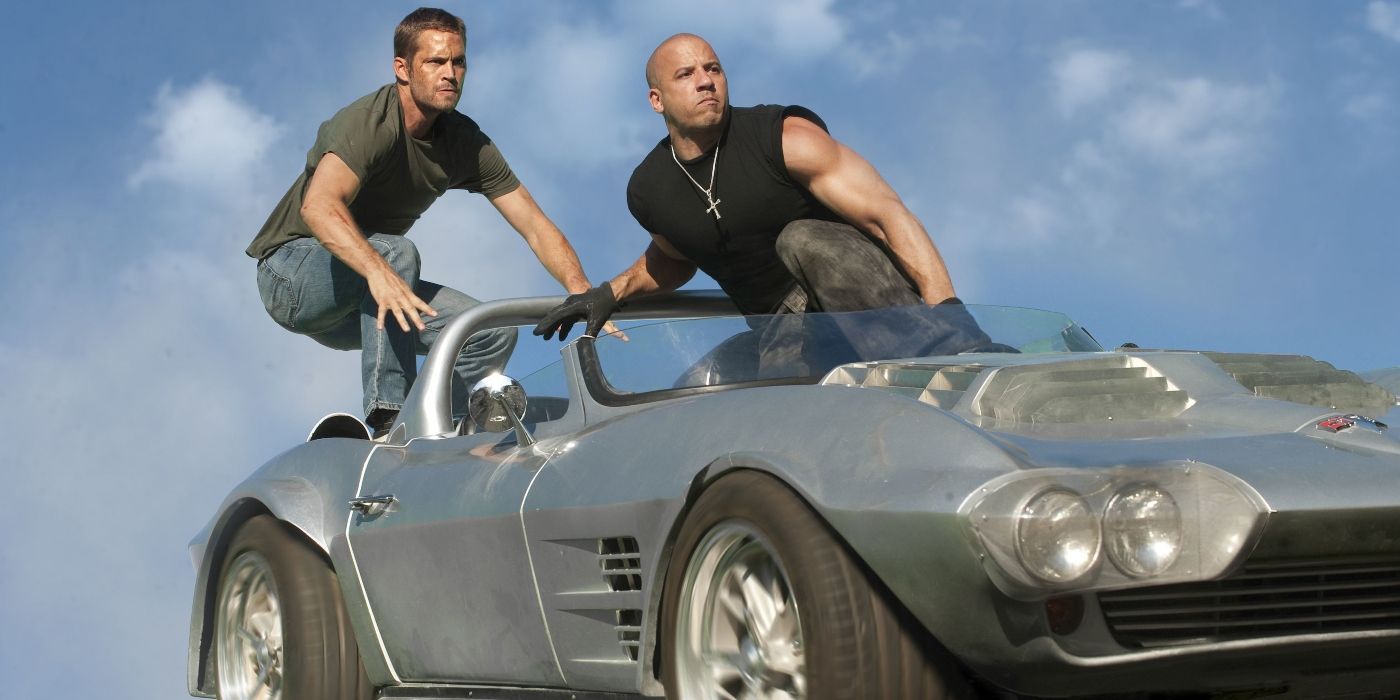 Paul Walker y Vin Diesel, quienes interpretan a Brian y Dom, están parados encima de un auto en Fast & Furious: Mega Max. 