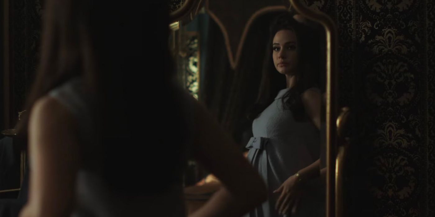 Cailee Spaeny as Priscilla Presley looking at herself through a mirror
