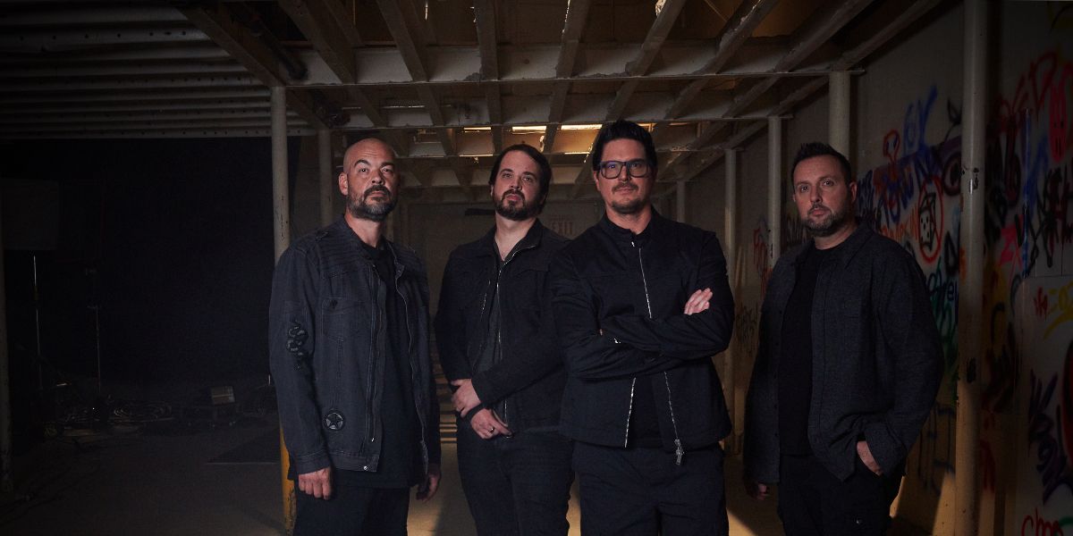 The cast of Ghost Adventures pose in a warehouse hallway