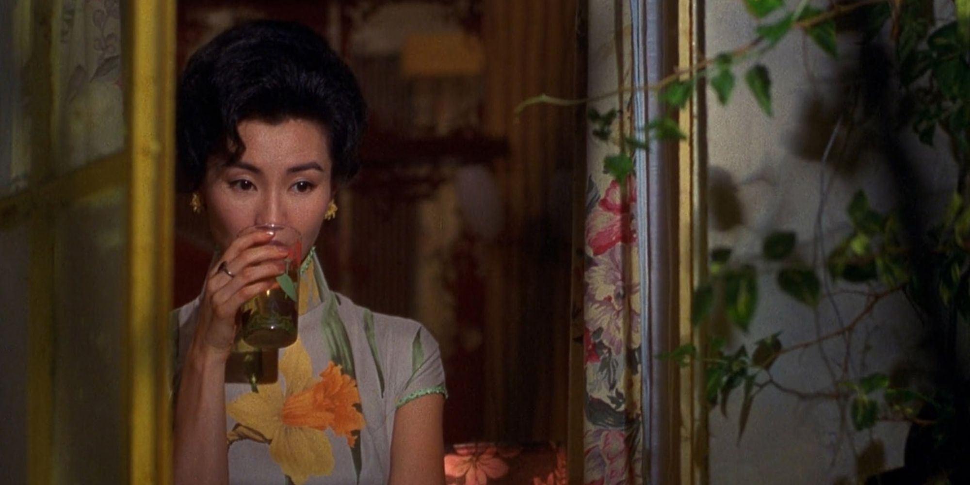 Maggie Cheung as Su Zi-Lhen looking out the window drinking in In The Mood for Love