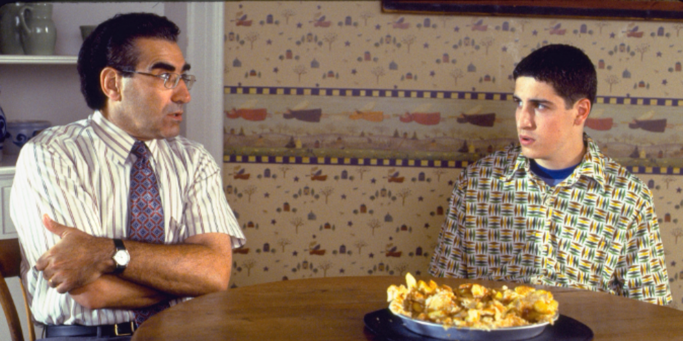 Jim and his dad sitting next to eachother with a destroyed apple pie in the table next to them in American Pie.