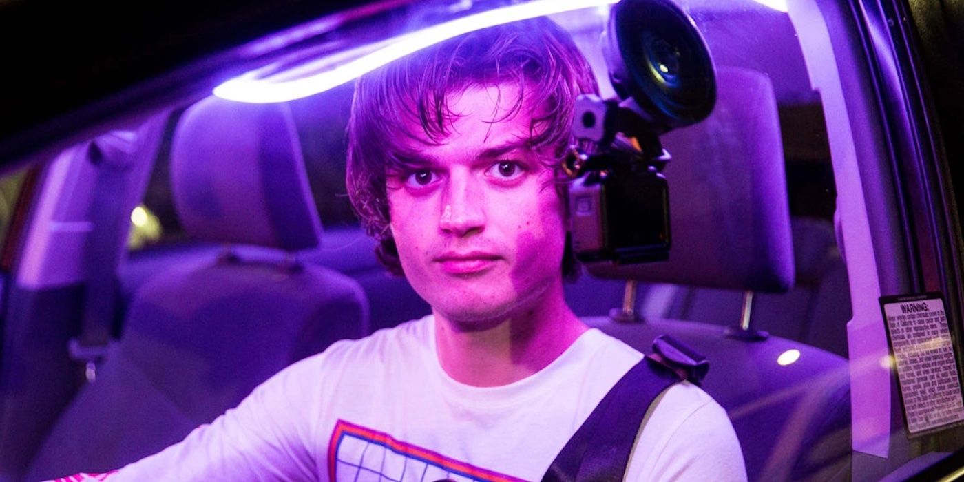 Joe Keery as Kurt Kunkle sits in a car illuminated by pink light in Spree