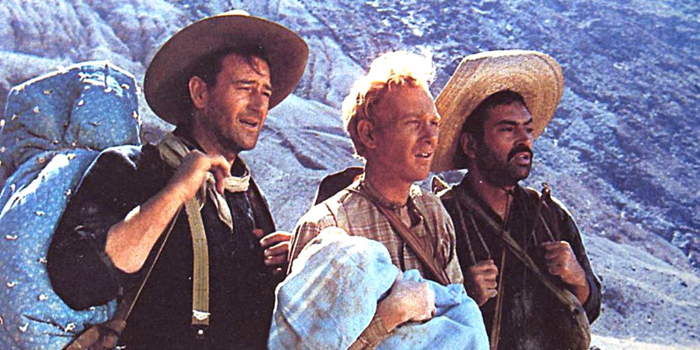 John Wayne, Harry Carey Jr. y Pedro Armendáriz de pie uno al lado del otro en un desierto en 3 Padrinos (1948)