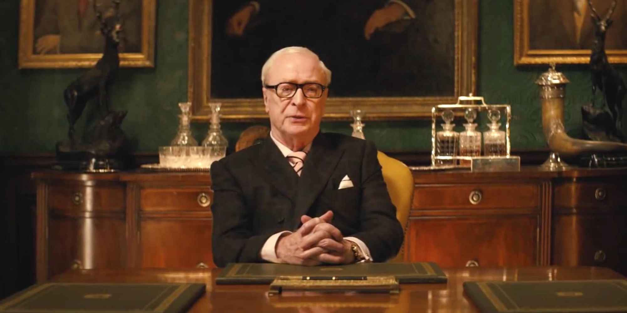 Michael Caine as Arthur, sitting at a desk in Kingsman: The Secret Service 