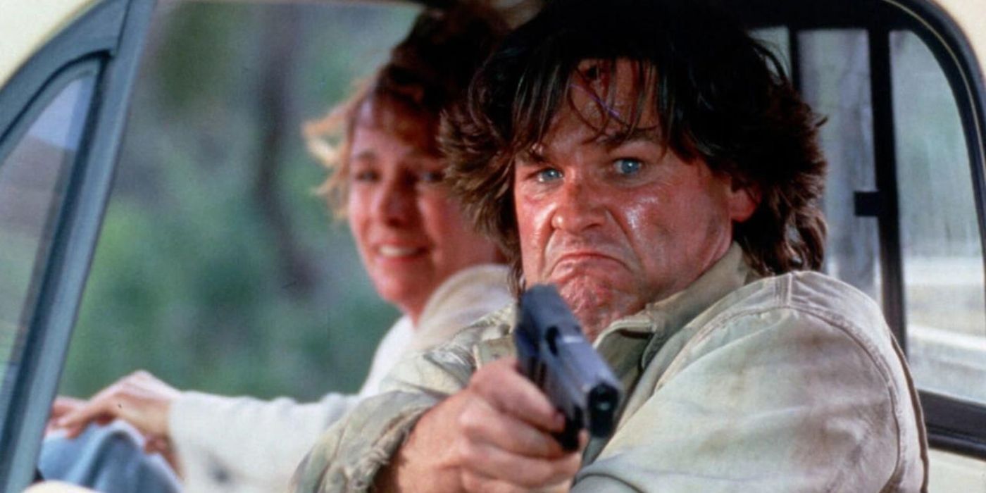 Kurt Russell como Jeff apuntando con un arma a alguien fuera de cámara en el colapso