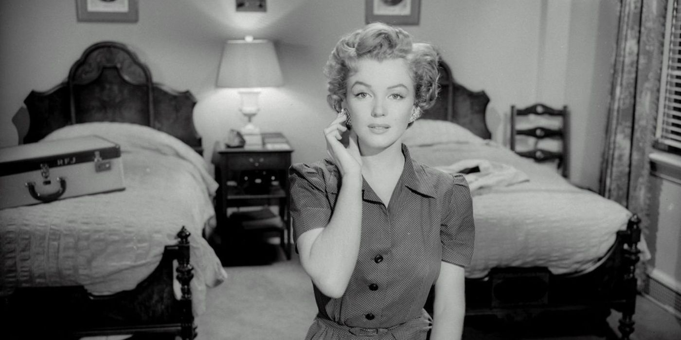 Marilyn Monroe sits touching earrings in Don't Bother Knocking