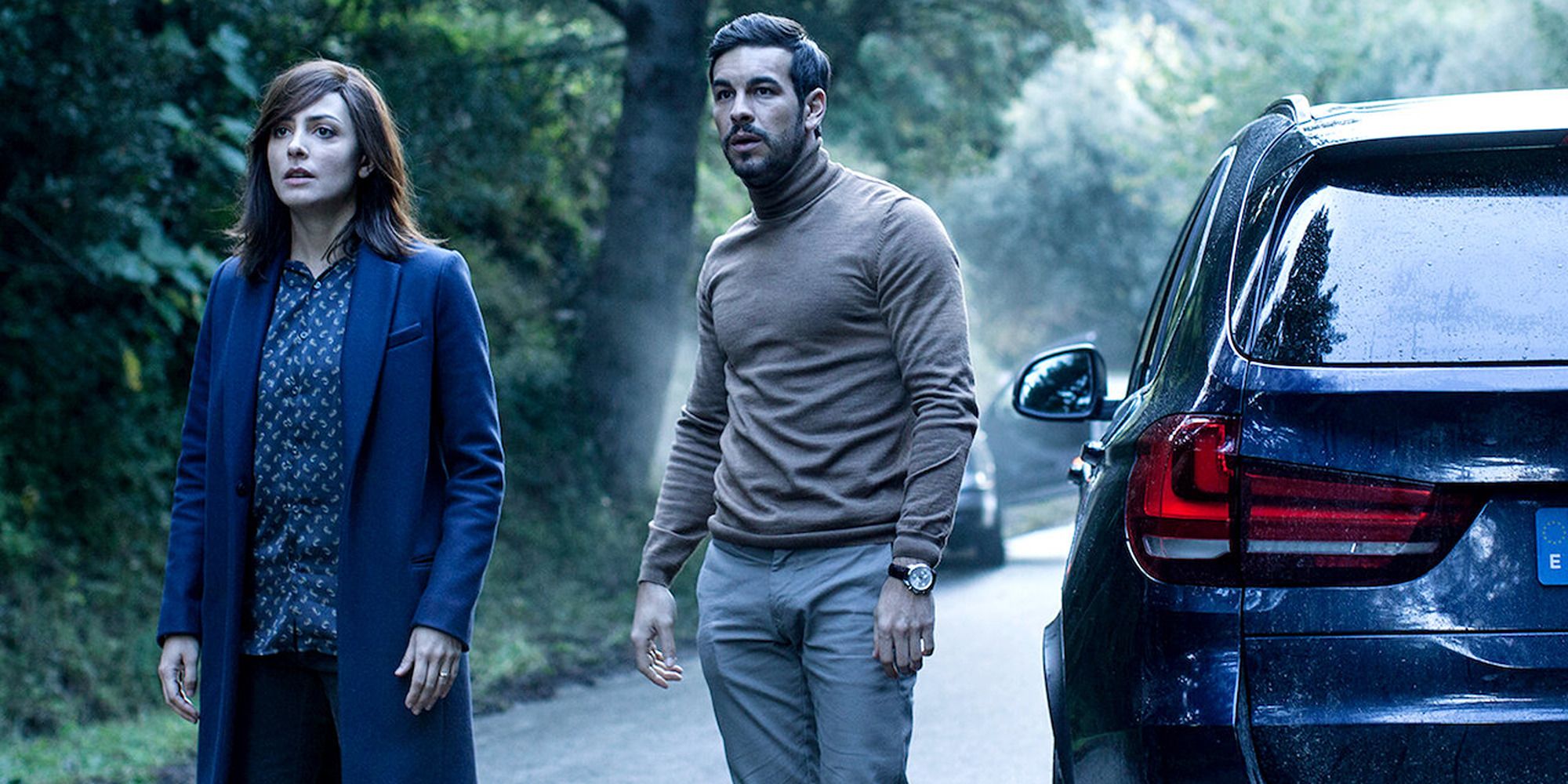 Mario Casas and Bárbara Lennie in &lsquo;The Invisible Guest&rsquo; standing on the road next to a car