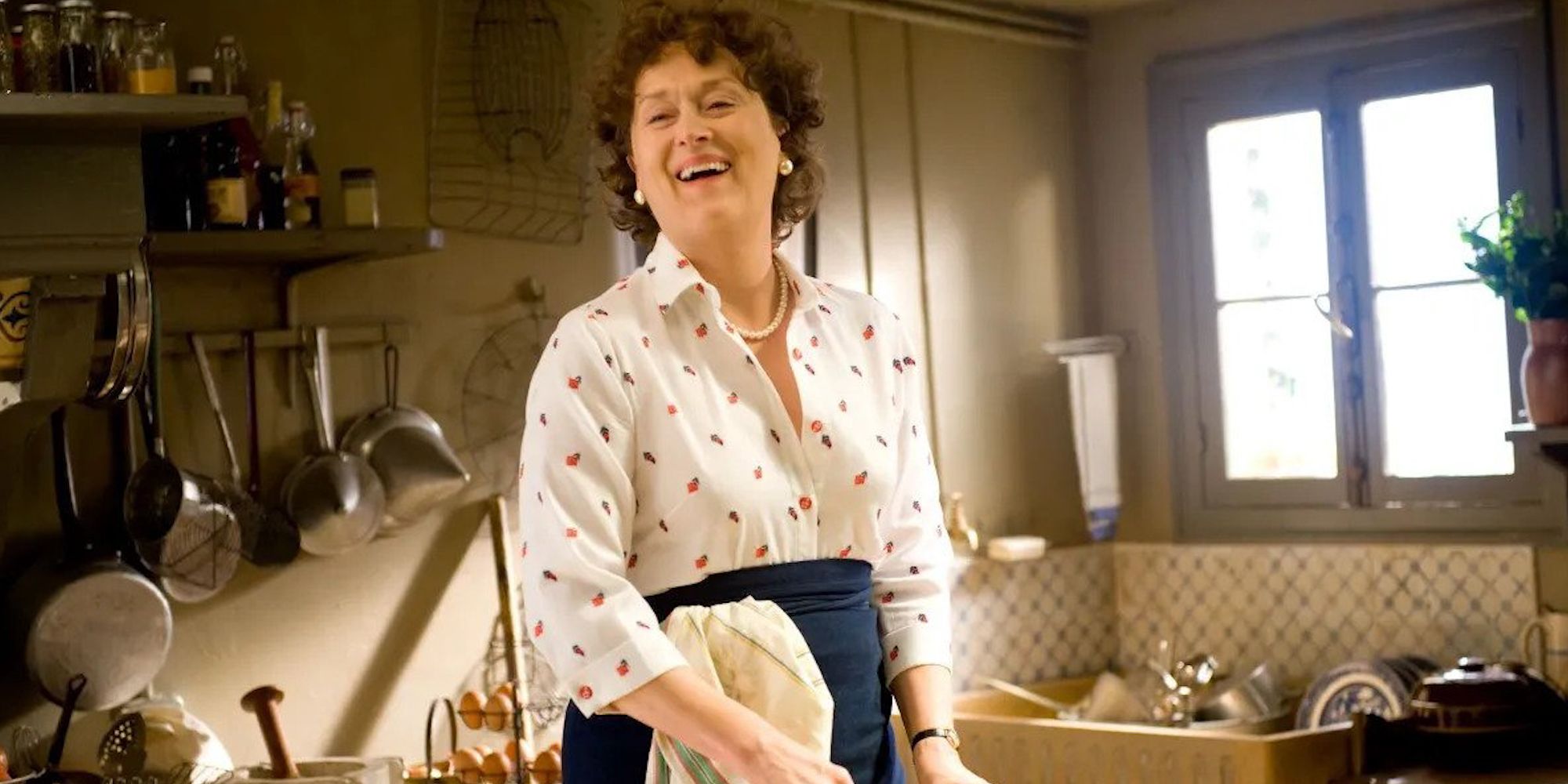 Meryl Streep as Julia Child, laughing in the kitchen in Julie & Julia