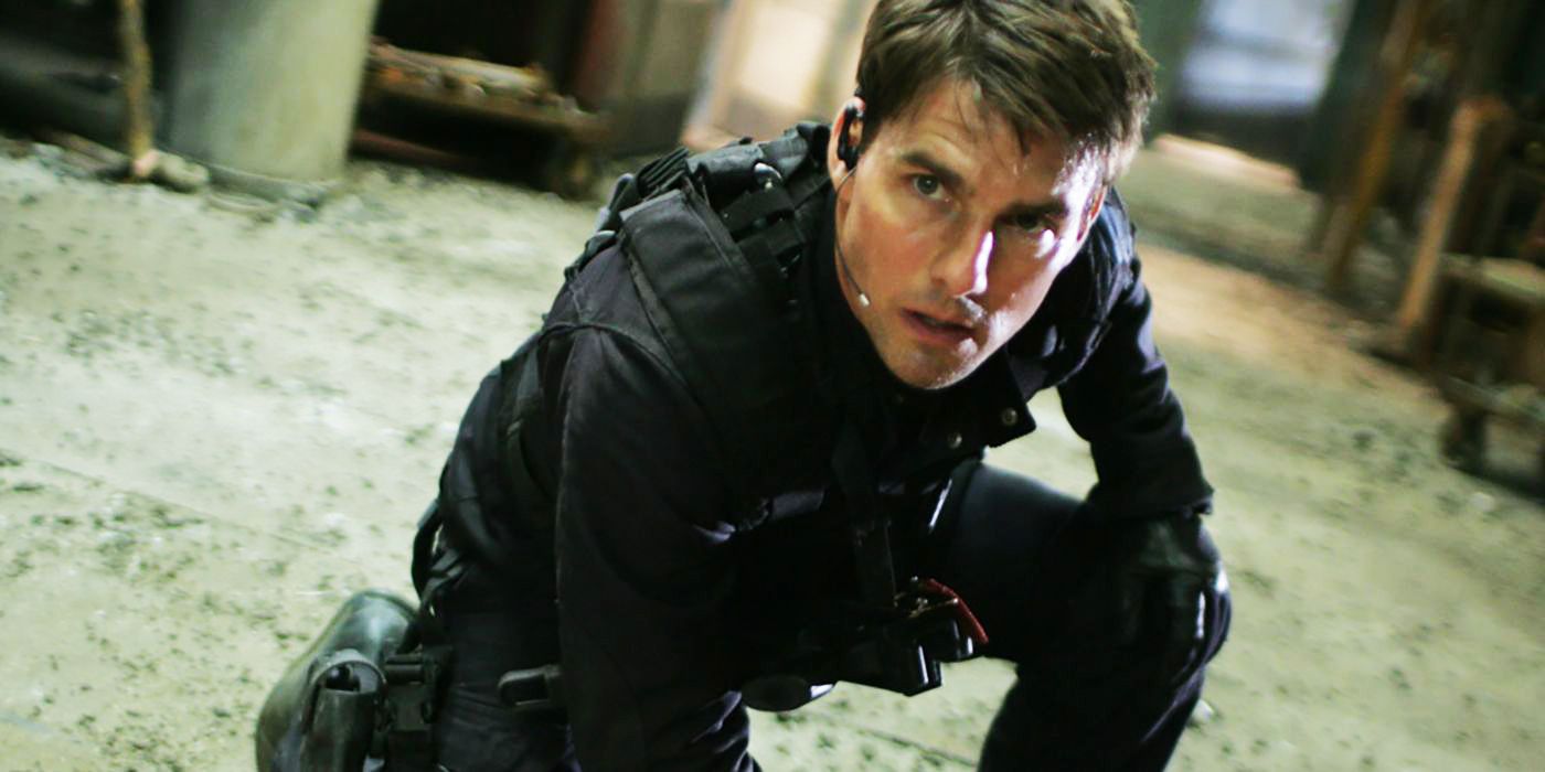 Tom Cruise as Ethan Hunt, crouched on the ground wearing stealth gear in Mission: Impossible III