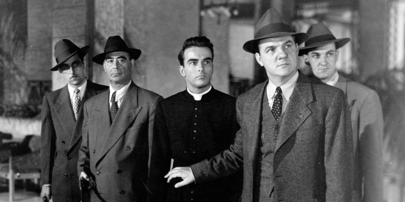 Montgomery Clift standing behind Karl Malden with several other men in I Confess