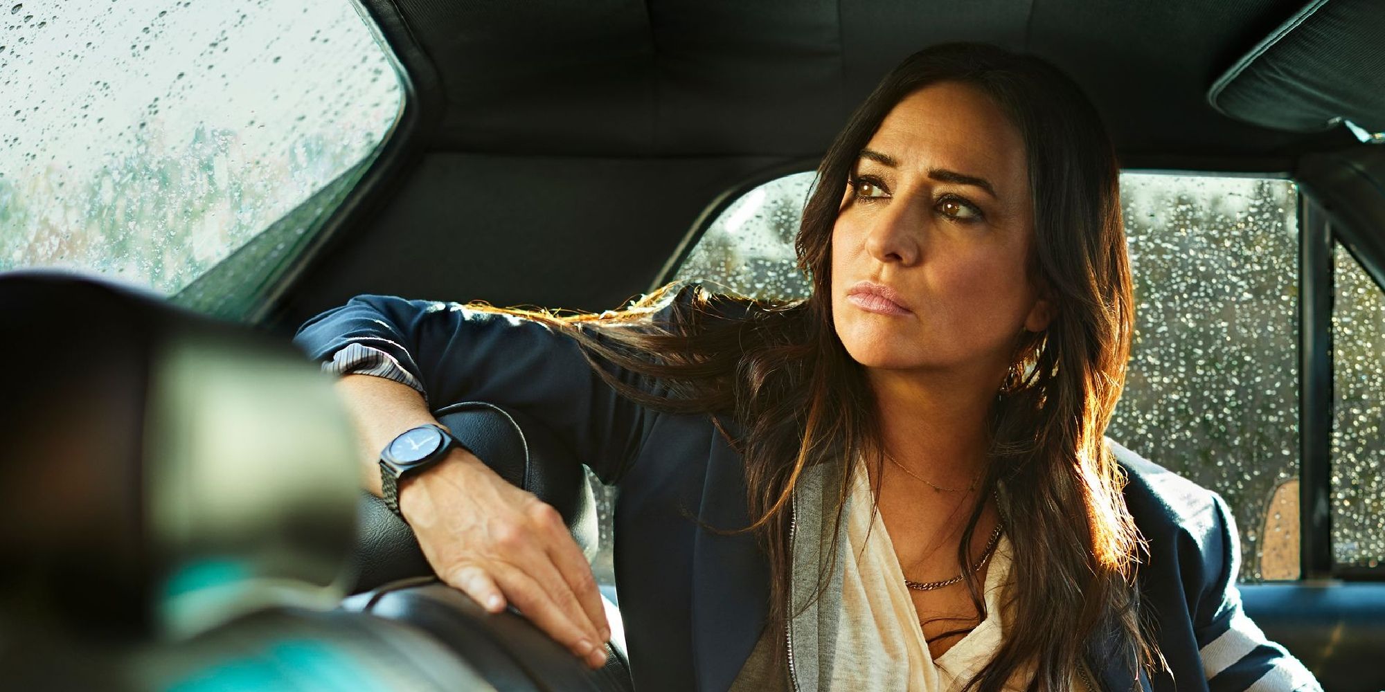 Pamela Adlon in Better Things sitting in the car, arm on the headrest looking back.