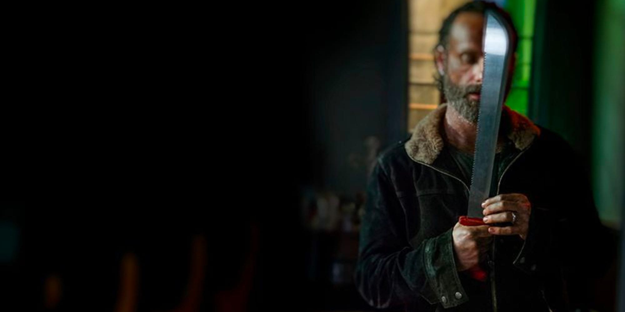 Rick Grimes stands in a darkened room with his red machete at the ready in 'The Walking Dead'