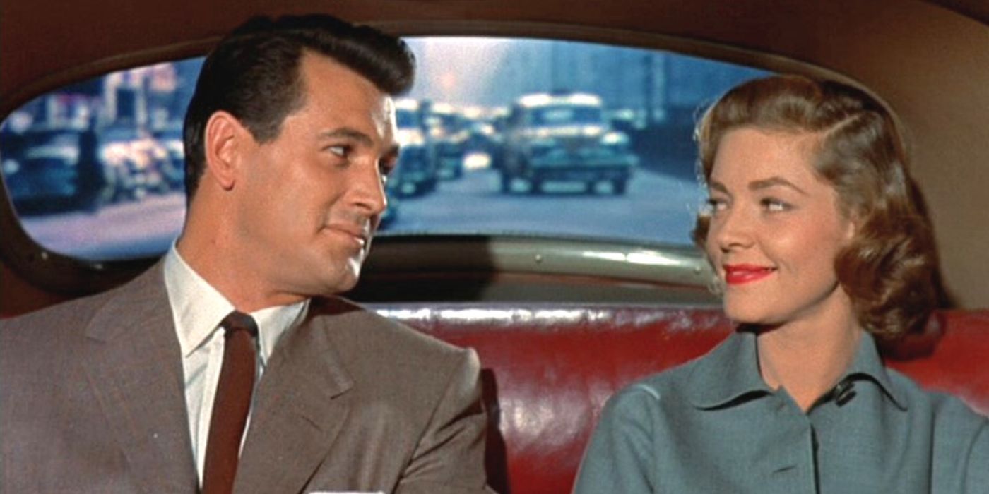 Rock Hudson and Lauren Bacall sitting together in the backseat of a car in Written on the Wind (1956).