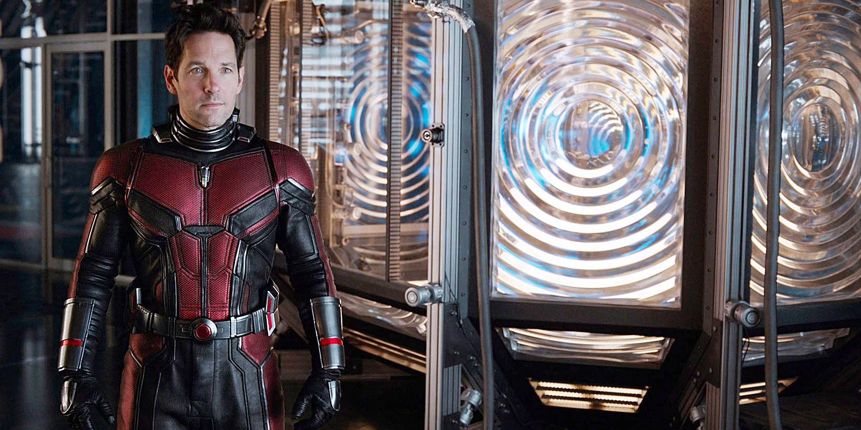 Scott Lang aka Ant-Man stands in his suit in a laboratory.