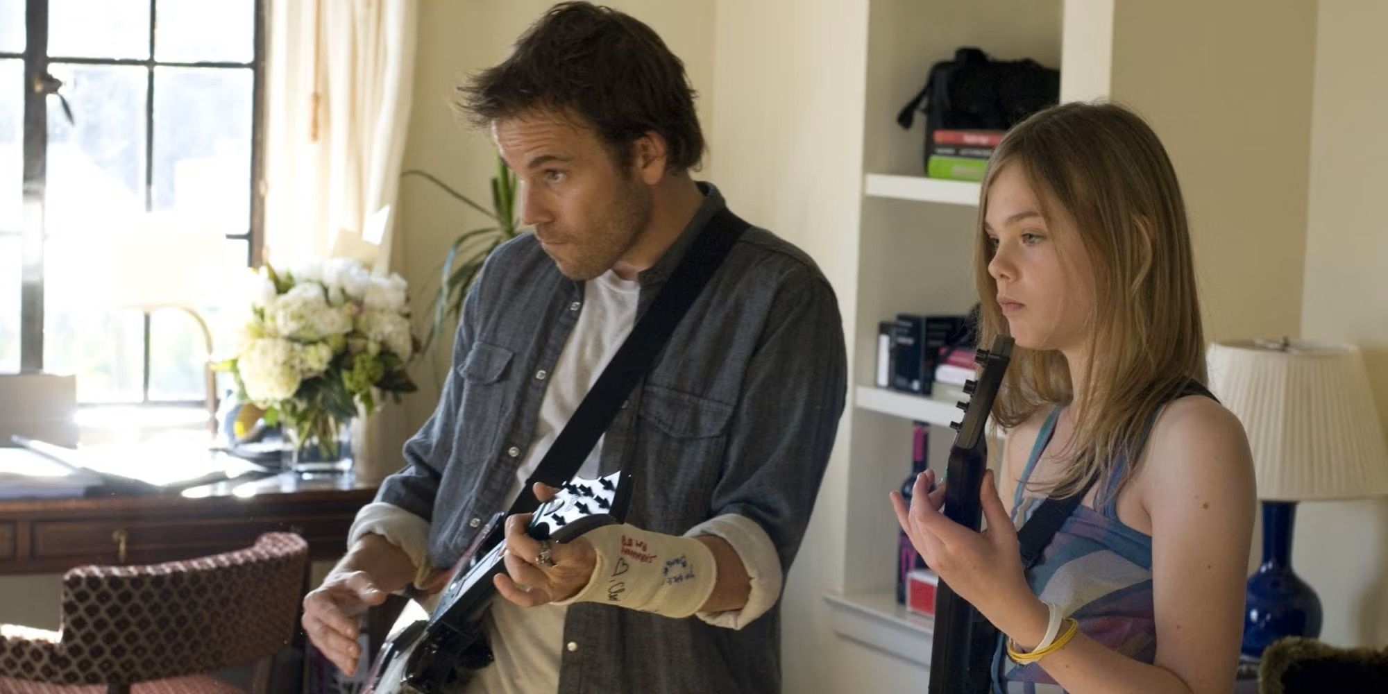 Stephen Dorff and Elle Fanning in 'Somewhere' playing guitar.