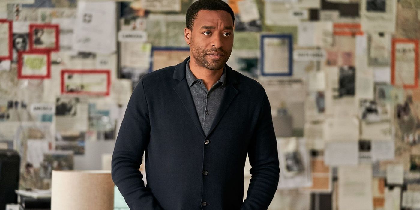 Chiwetel Ejiofor standing in front of a board covered with papers in The Old Guard