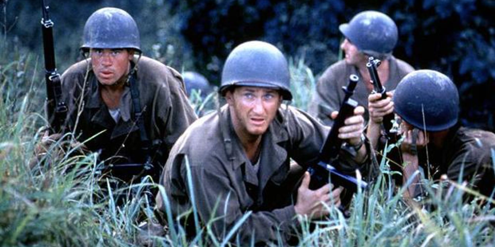 A group of soldiers crouches in the tall grass in The Thin Red Line’ (1998)