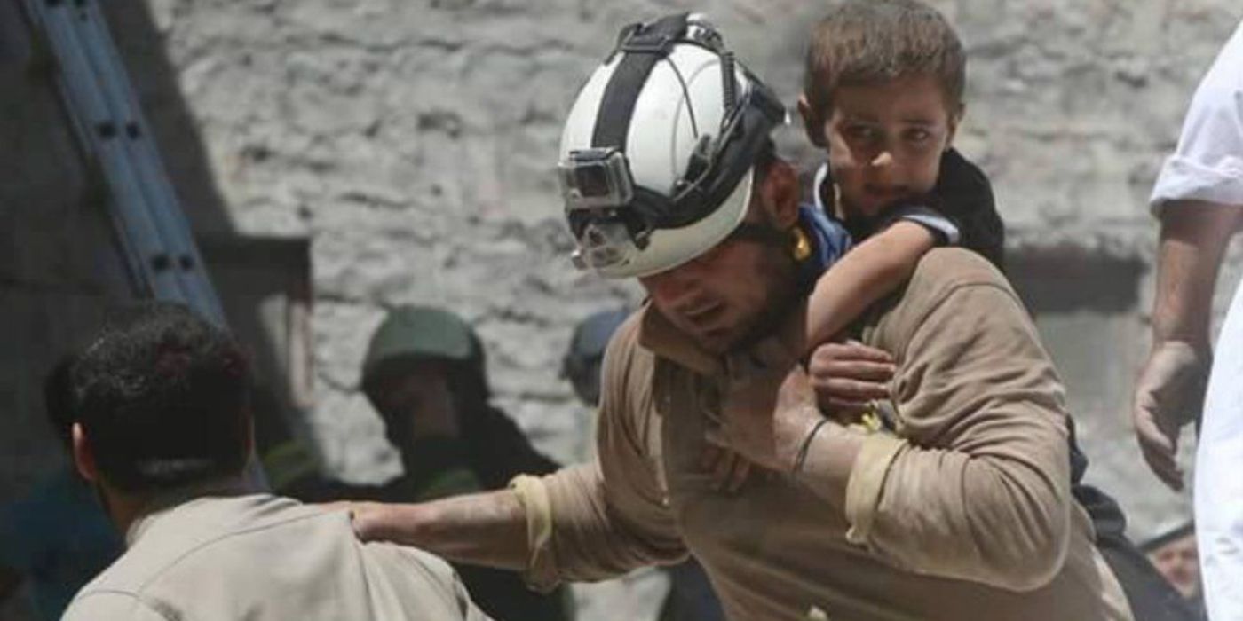 A White Helmets volunteer rescues children in Syria. 