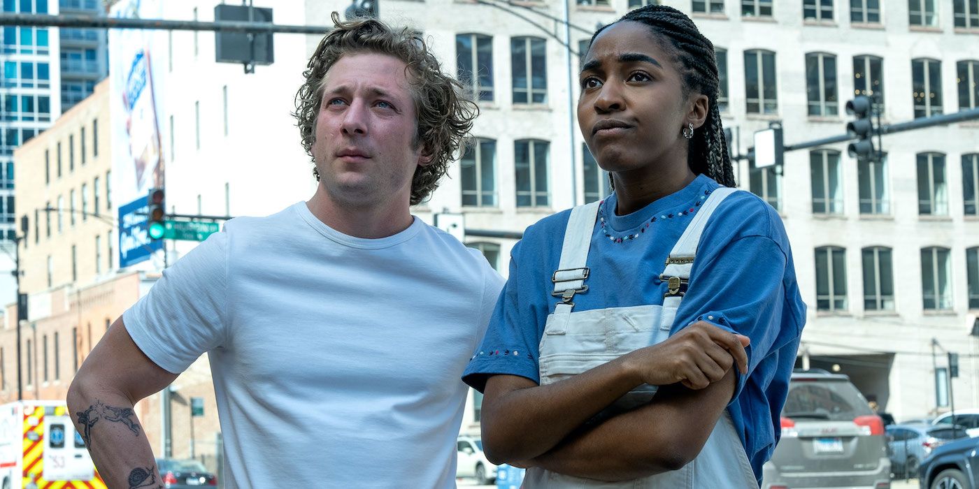 Jeremy Allen White as Carmy and Ayo Edebiri as Sydney standing in the streets looking offscreen contemplatively in The Bear Season 2. 