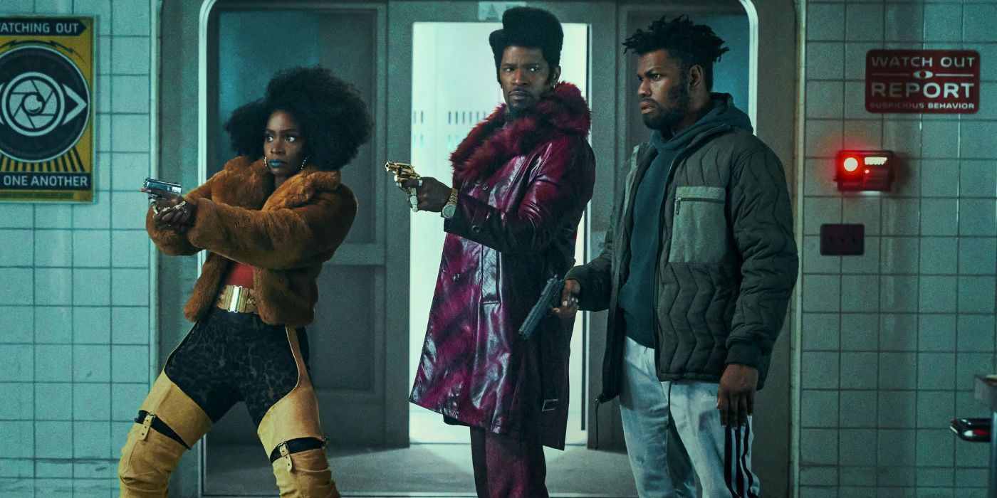  Fontaine (John Boyega), Yo-Yo (Teyonah Parris), Slick Rick (Jamie Foxx) holding their guns in a lab hall They Cloned Tyrone.