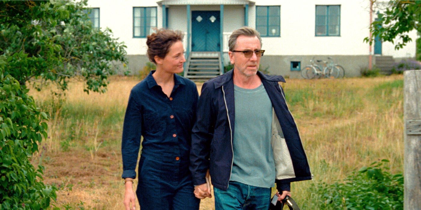 Tim Roth and Vicky Krieps walking away from a house together in Bergman Island (2021)