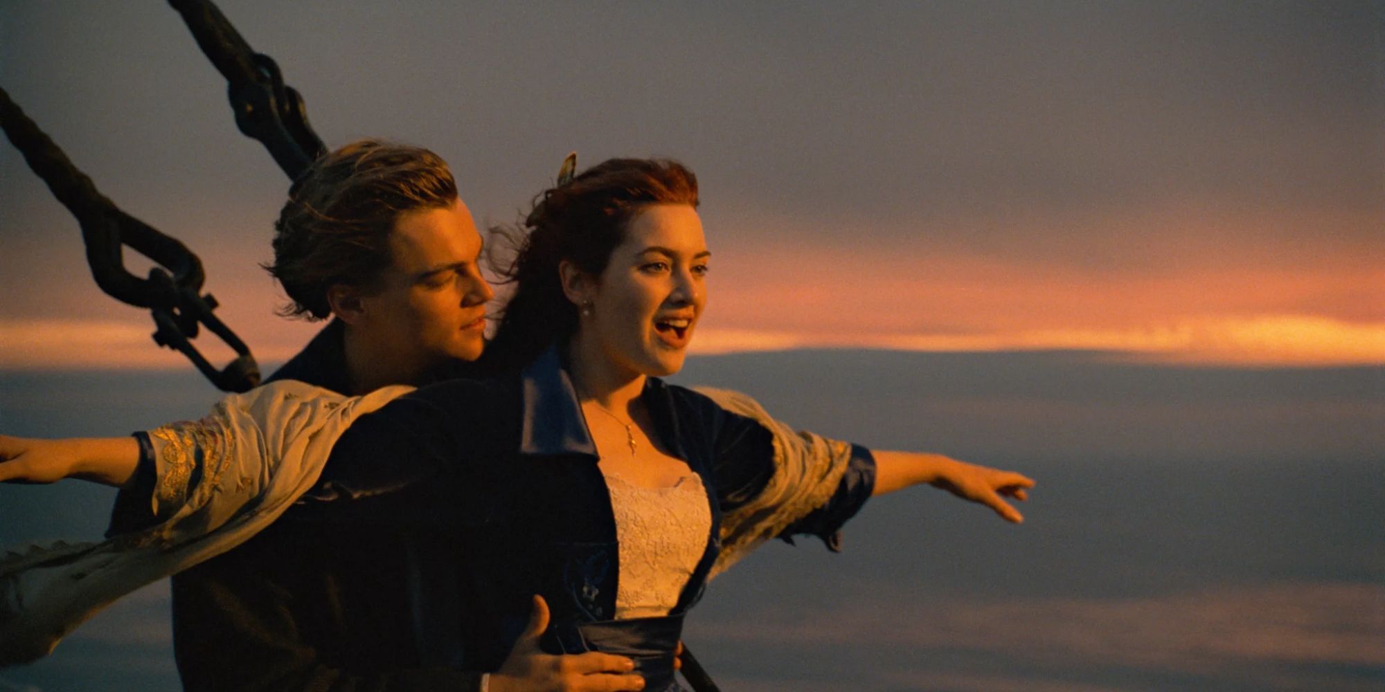 Jack holds Rose, who has her arms open wide, on the bow of the 'Titanic'