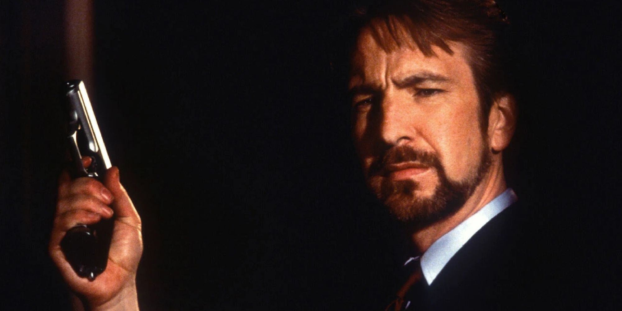 Alan Rickman holding a gun in Die Hard