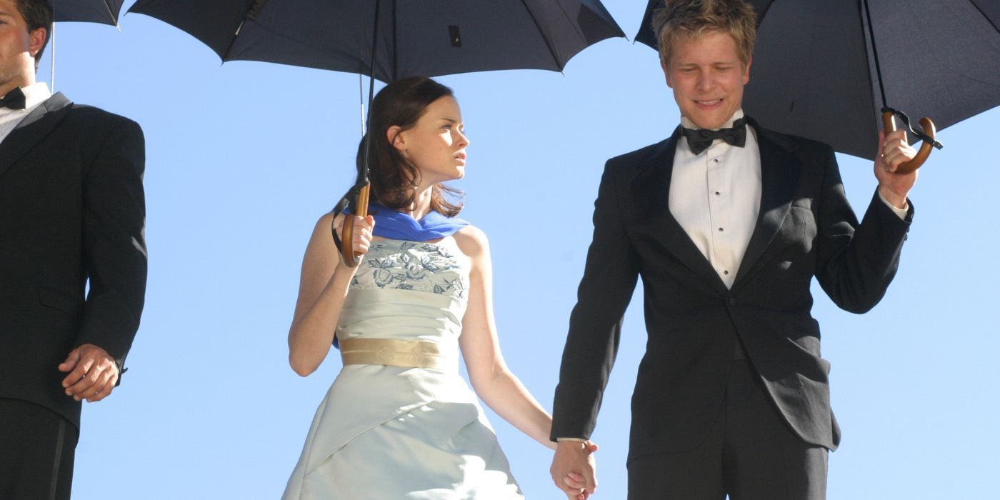 Rory and Logan holding hands and umbrellas in Gilmore Girls