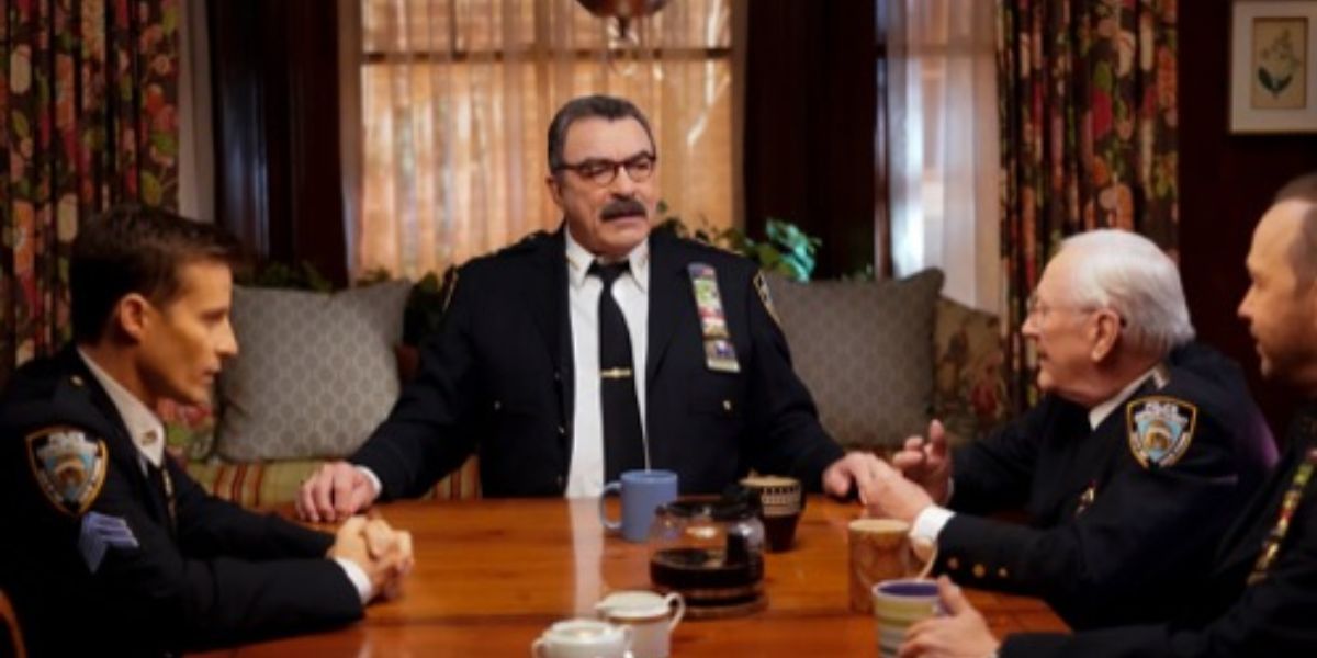 Four men sitting around a table in their police uniforms.