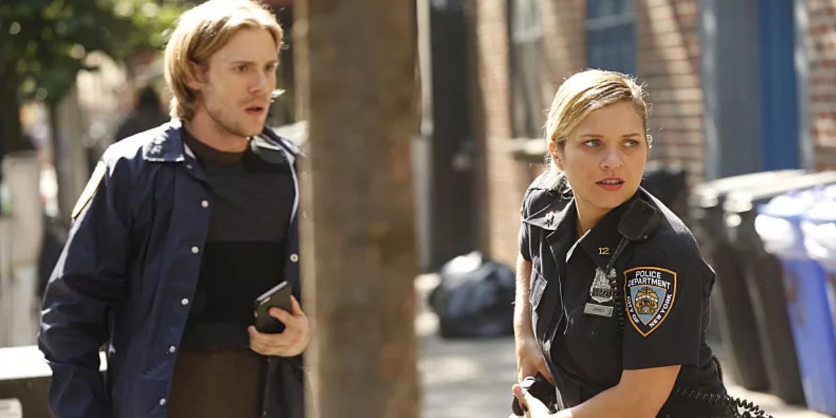 A man holding a cell phone standing next to a woman in a police uniform reaching for her gun.