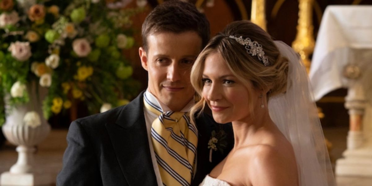 A man in a suit standing next to a woman in her wedding gown.