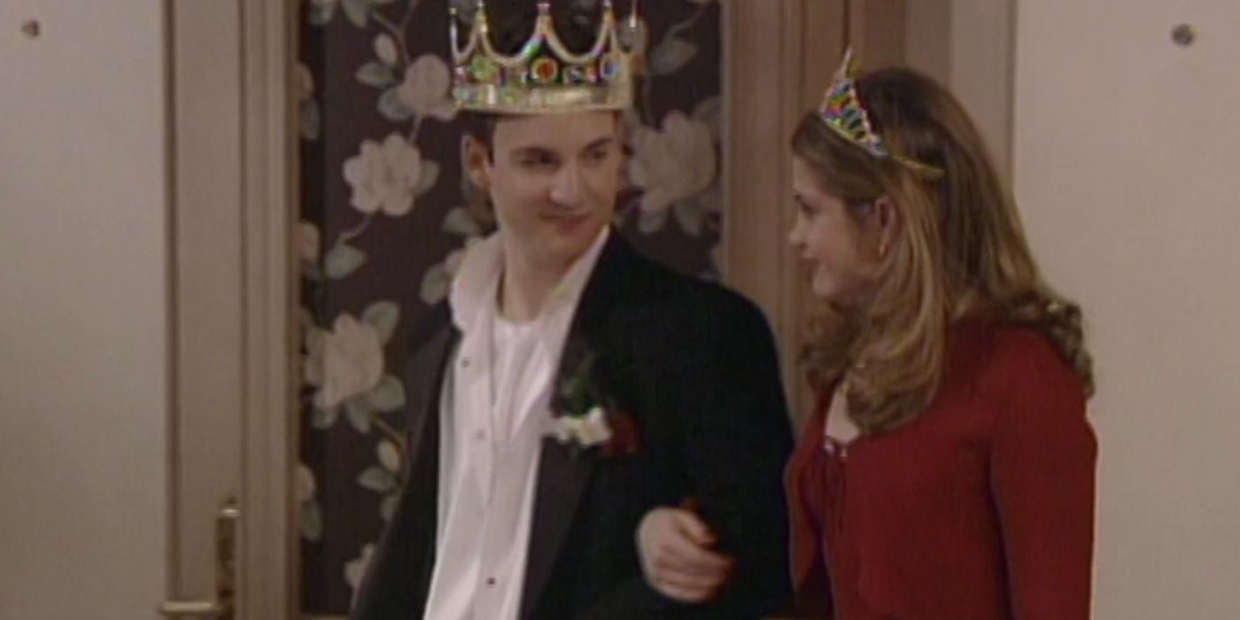 Cory (Ben Savage) and Topanga (Danielle Fishel) wearing prom king and queen crowns and smiling at each other in a hotel room in Boy Meets World