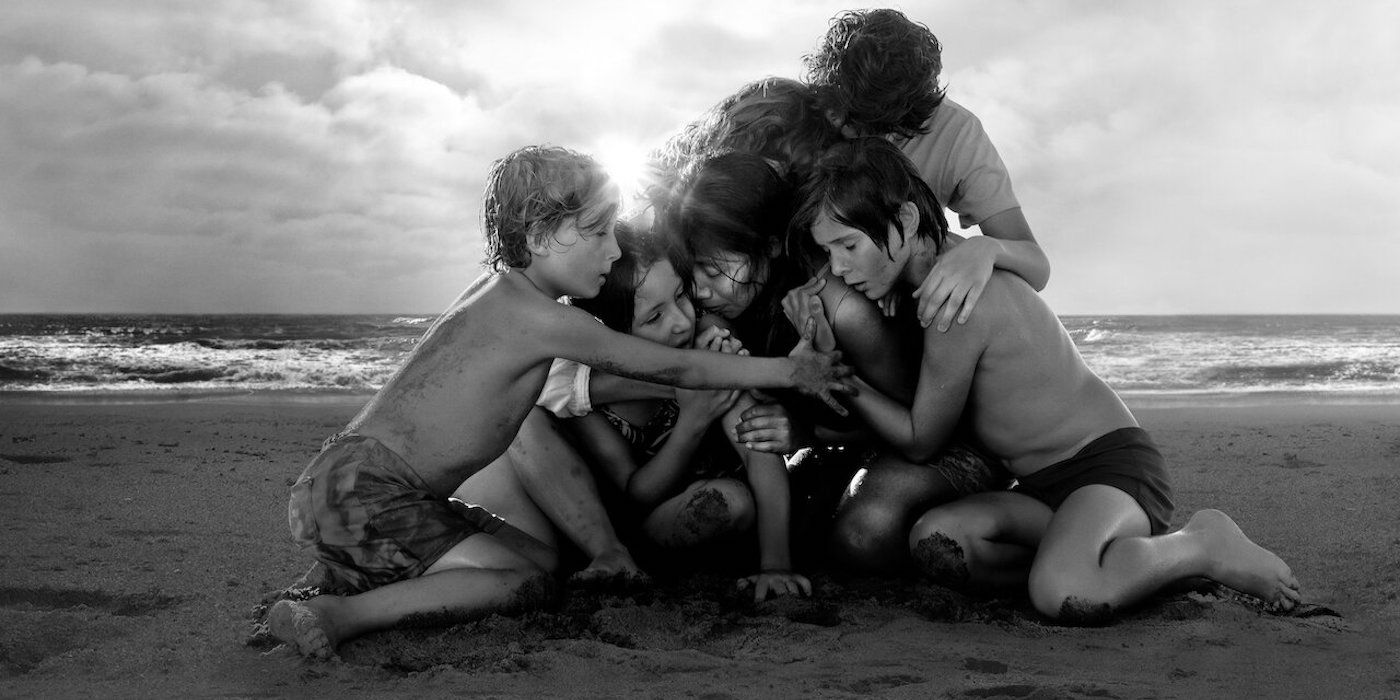 The cast of Roma, huddled on the beach