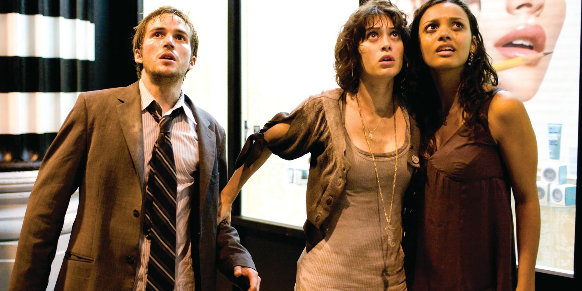 Michael Stahl-David, Lizzy Caplan, and Jessica Lucas as Rob, Marlena, and Lily, holding each other in the street and looking up at something in Cloverfield