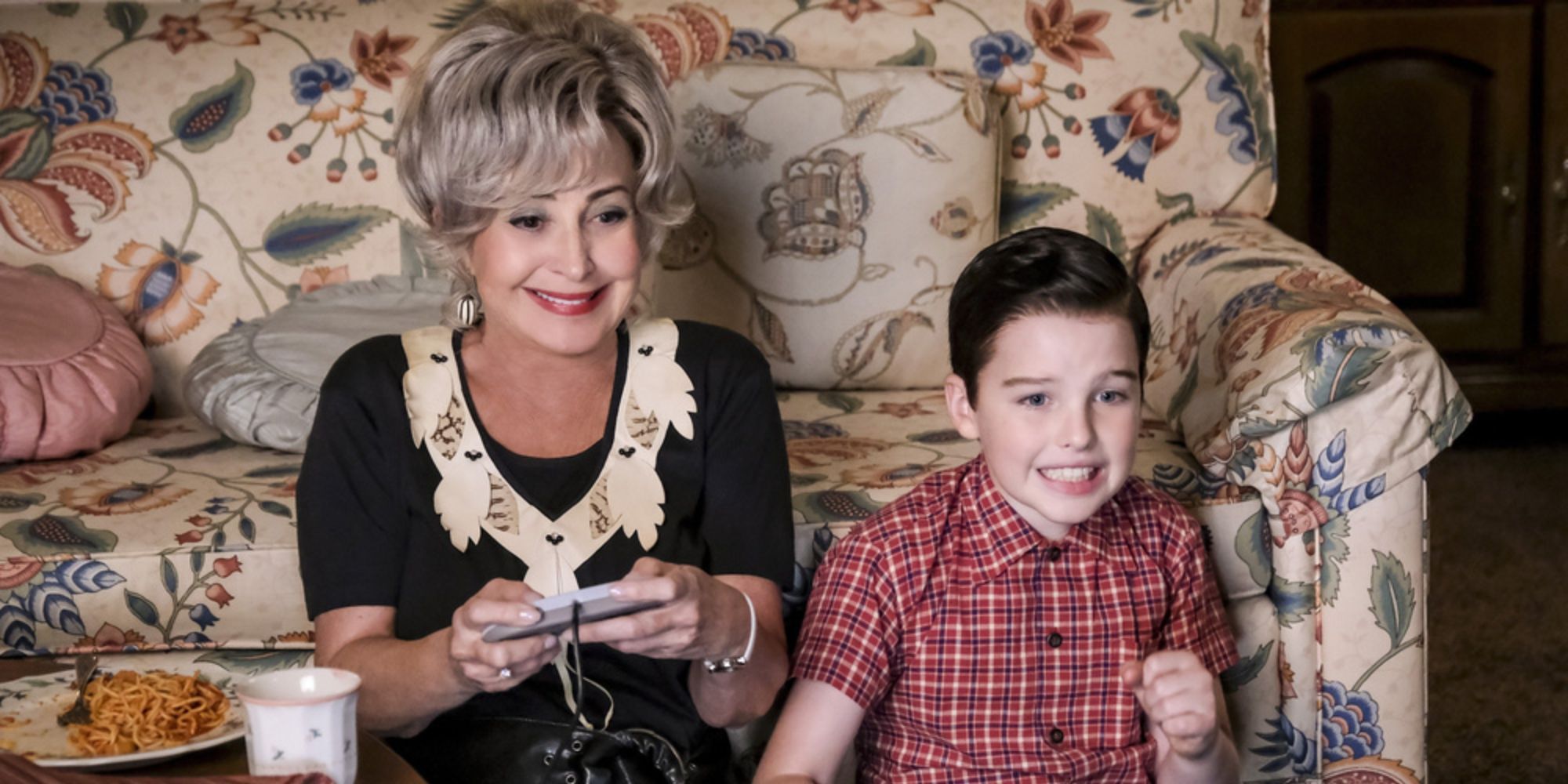Sheldon Cooper, played by Iain Armitage, watches his Meemaw, played by Annie Potts, try out his favorite video game.