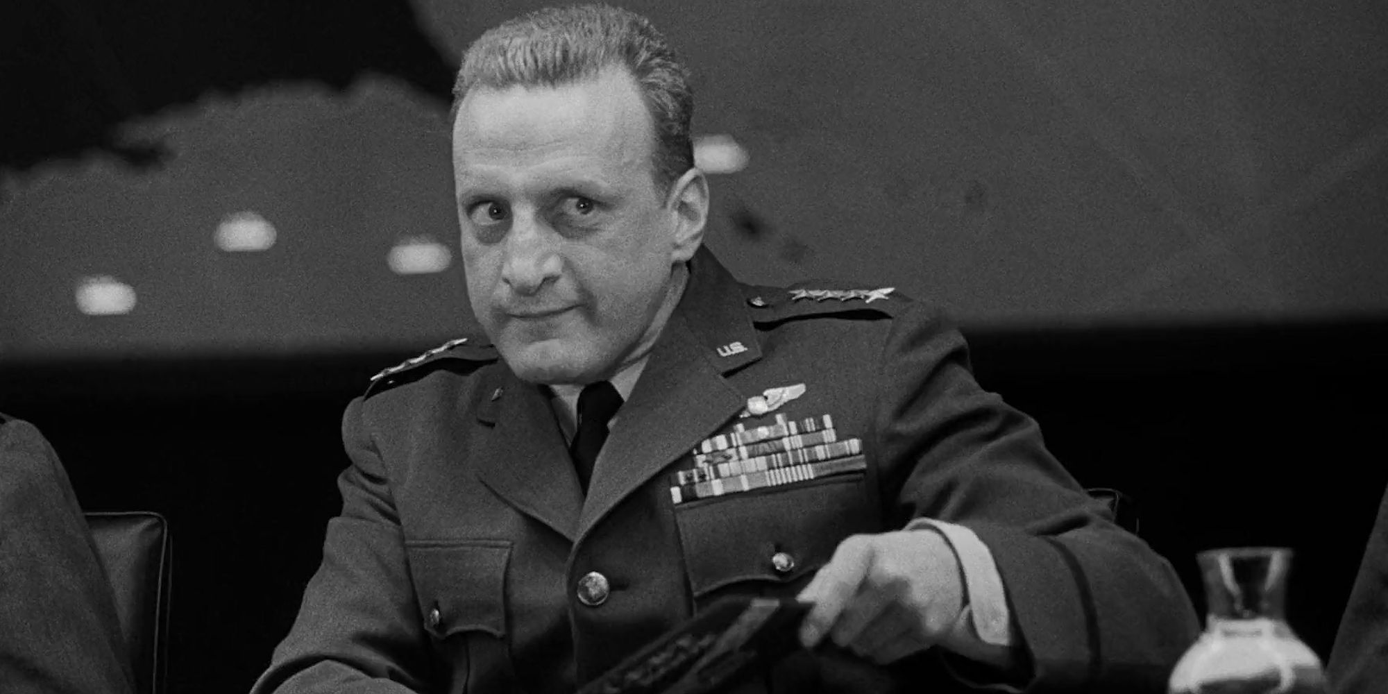 George C. Scott as Gen. 'Buck' Turgidson pointing at a person offscreen in Dr. Strangelove