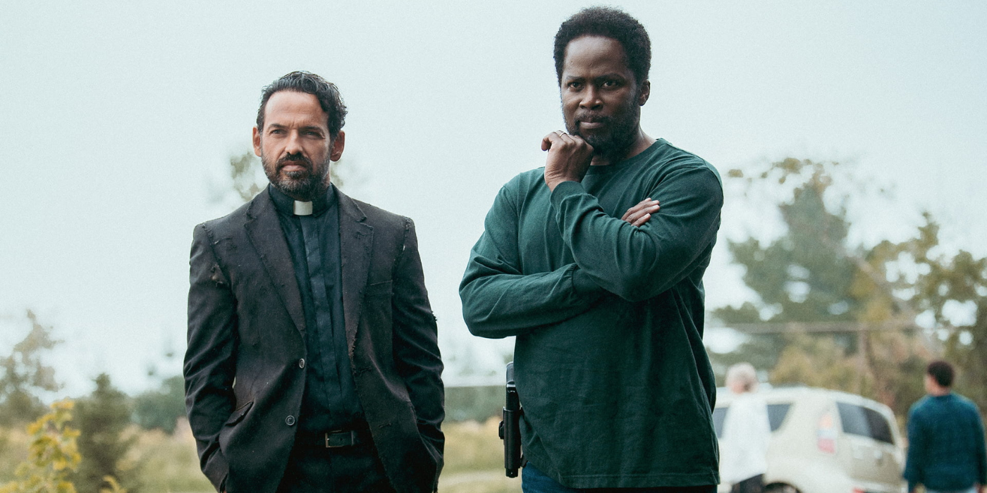 Shaun Majumder as Father Khatri and Harold Perrineau as Boyd standing next to each other outside in From