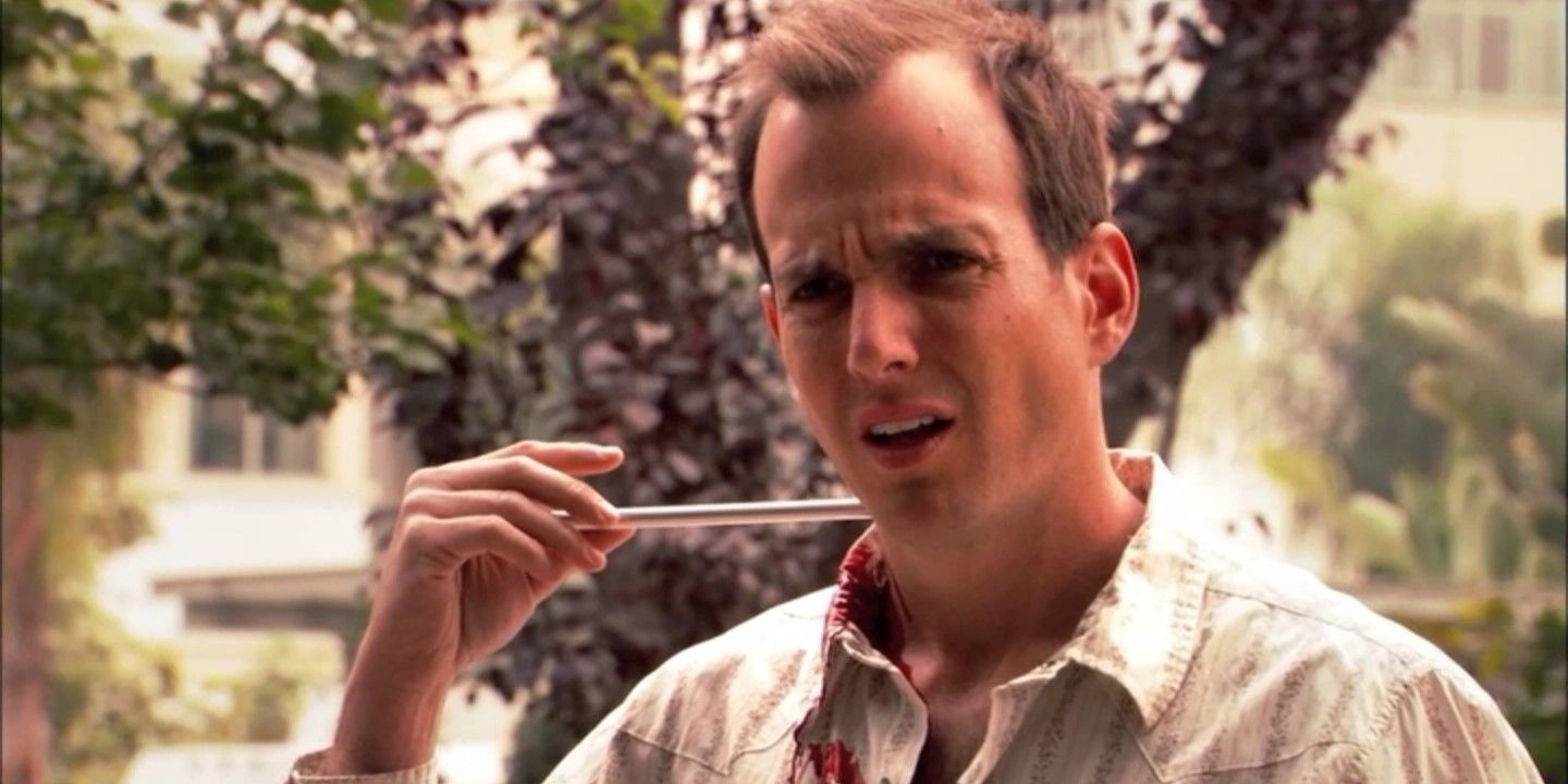 Still from 'Arrested Development': Gob Bluth (Will Arnett) stands looking concerned holding a sharp object piercing the side of his neck.