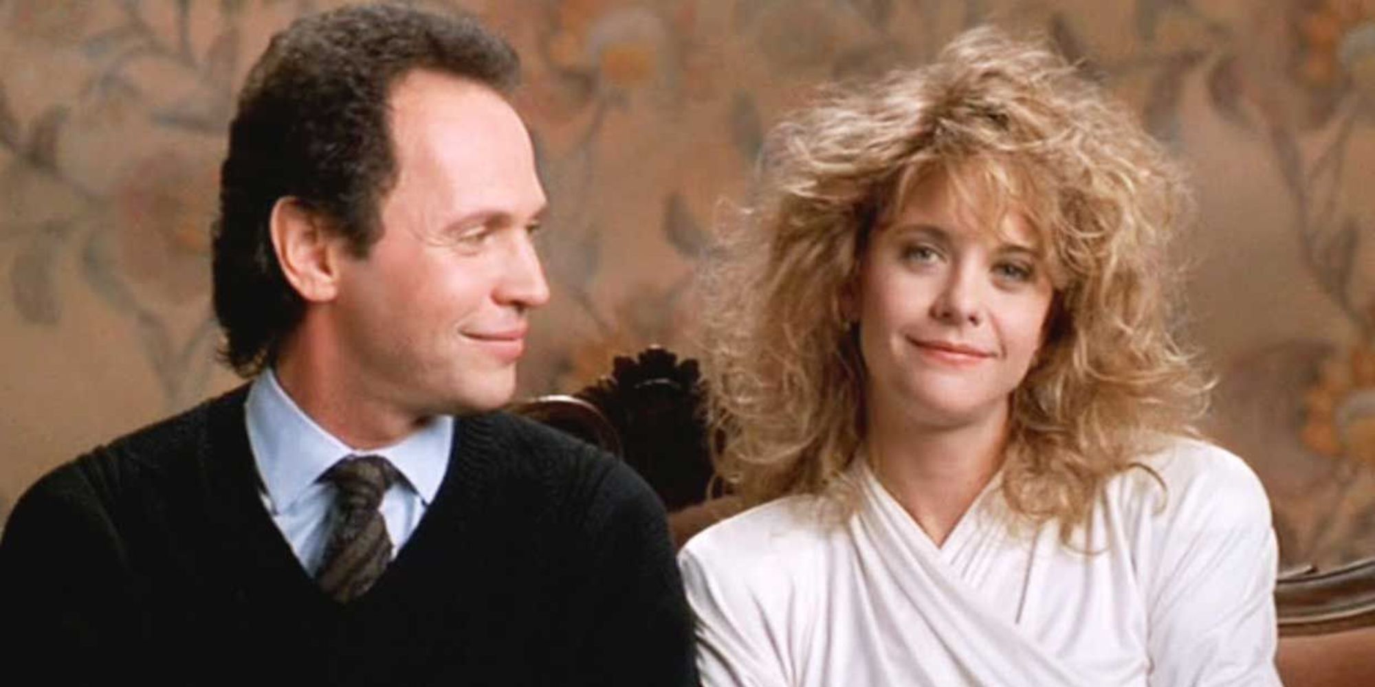 Billy Crystal looks at Meg Ryan who is looks at the camera smiling in When Harry Met Sally