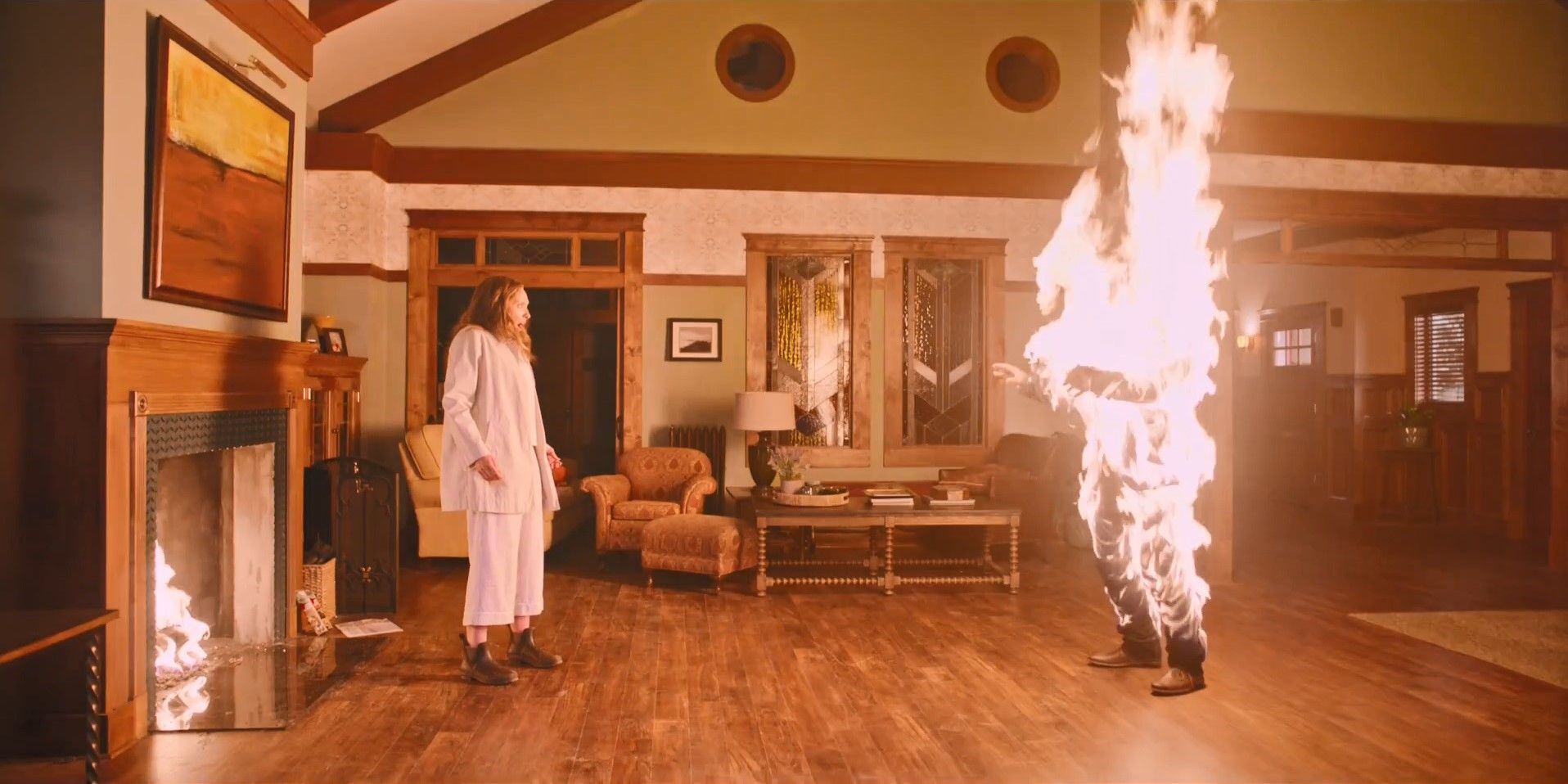 Still from "Hereditary": Annie (Toni Collette) stands in front of a figure on fire.