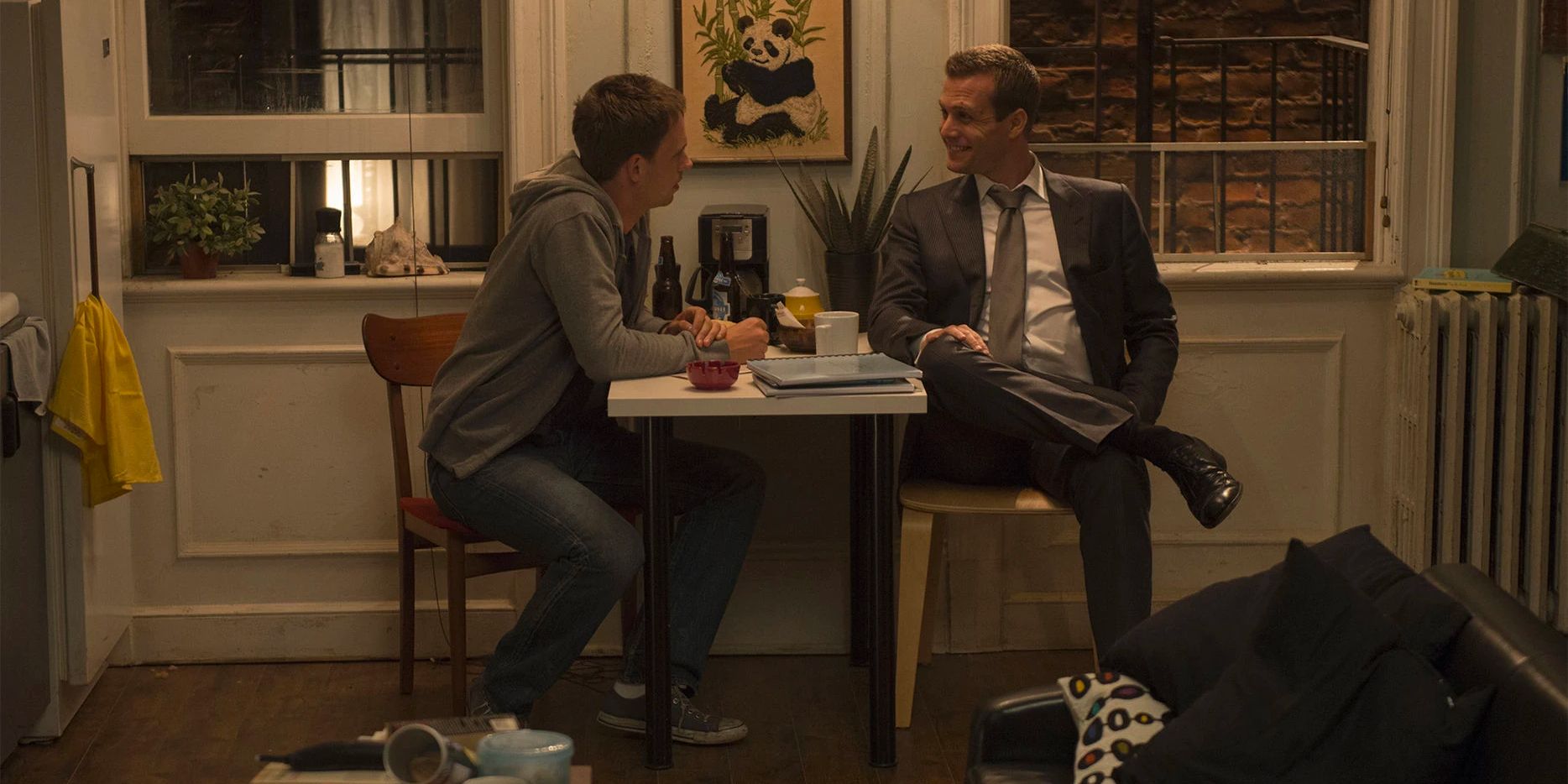 Harvey Spectre (Gabriel Macht) and Mike Ross (Patrick J. Adams) sit in Mike's messy apartment in discussion.
